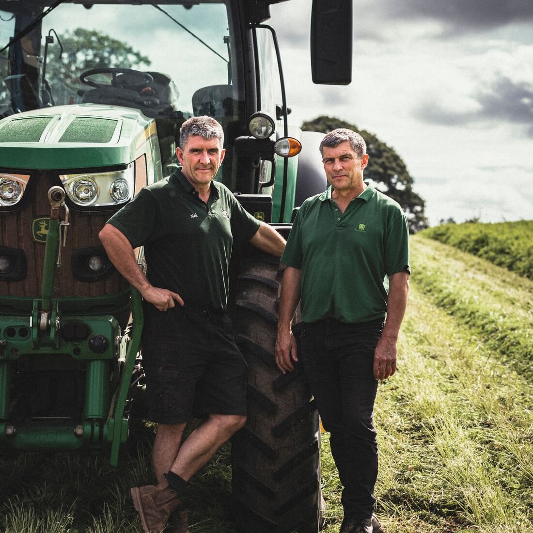 Neil and Gary Farley stand beside their tractor on their farm in Devon.