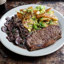 Sirloin steak, mushroom and red wine sauce with sauté potatoes and shredded sprouts